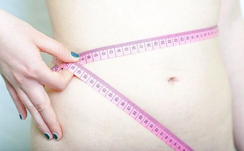 Unha nena mide a cintura para rexistrar os resultados de seguir a dieta Dukan